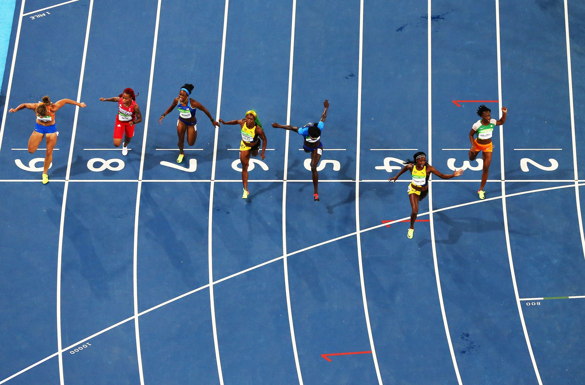 Des athlètes franchissent la ligne d'arrivée d'une course d'athlétisme.